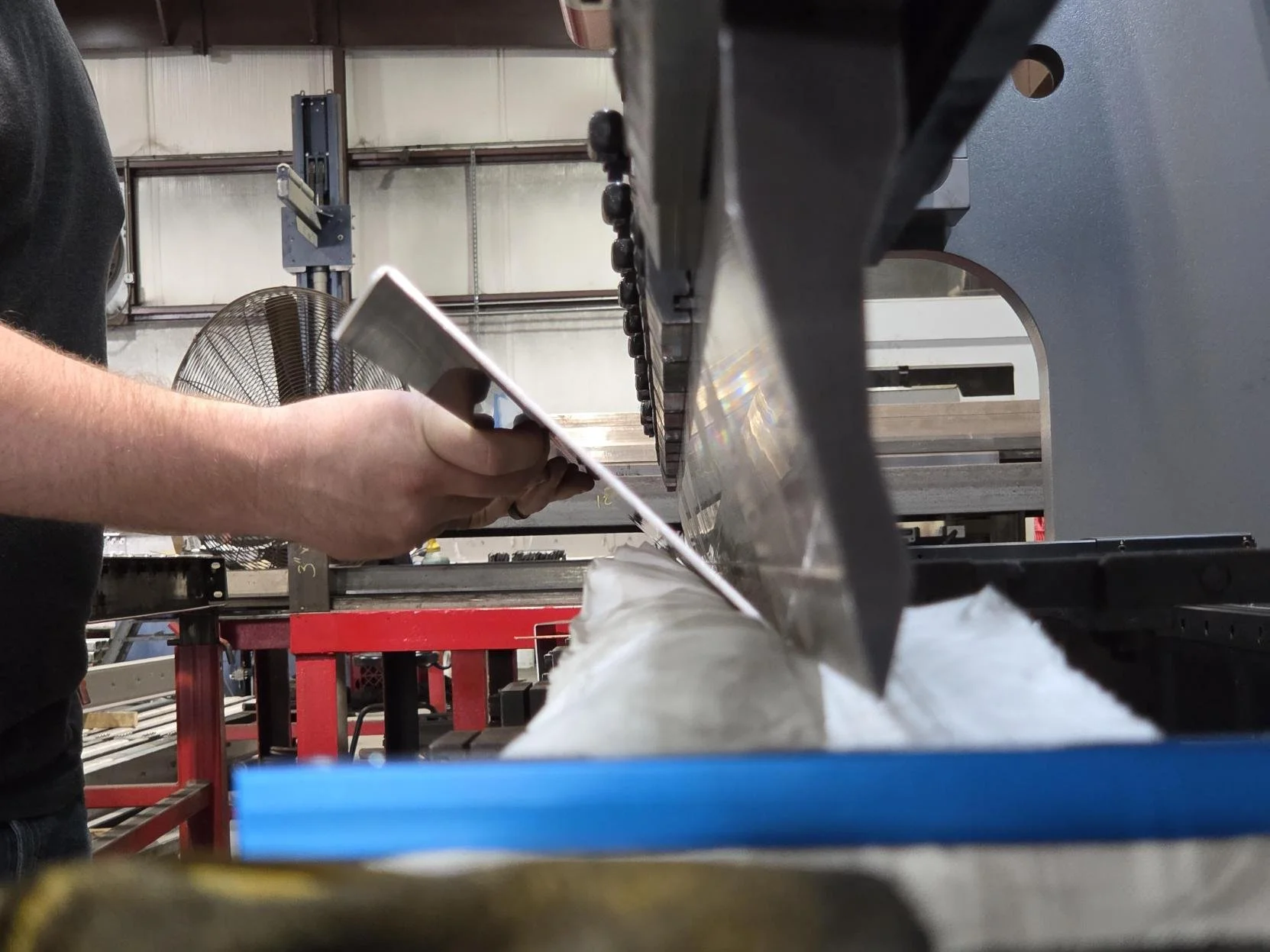 A person working with a piece of machinery in an industrial or workshop setting.