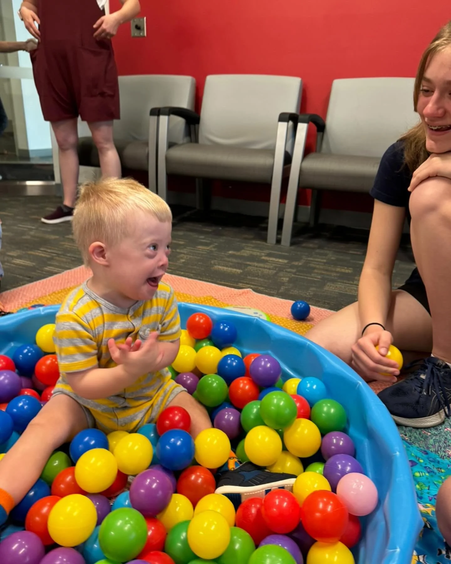 Caucasian toddler with Down syndrome playing in a ballpit