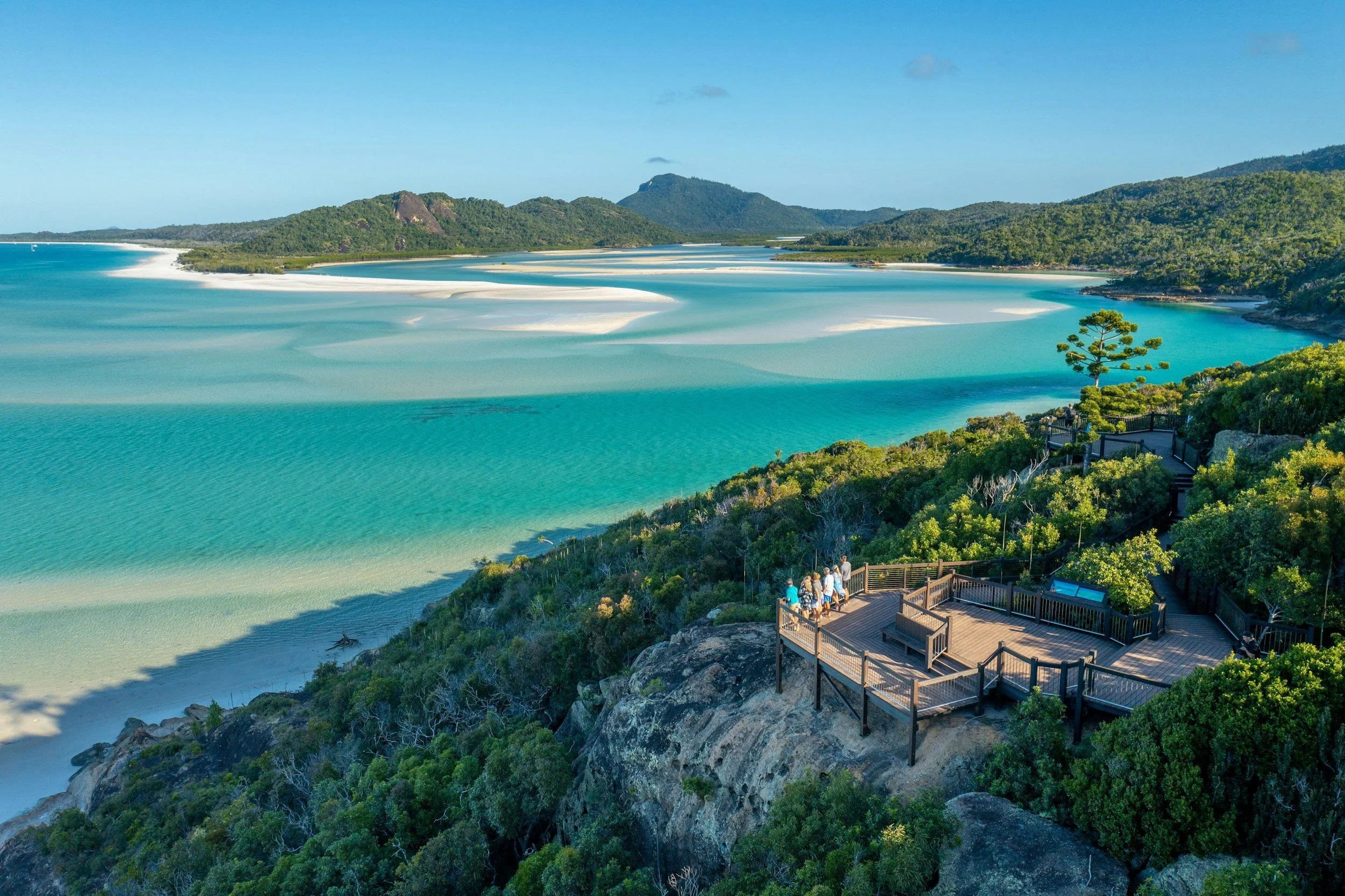 People standing on a wooden lookout above turquoise water and swirling white sand in Australia. It’s the kind of unplugged holiday view freelance designers can enjoy when their projects are planned around time off.