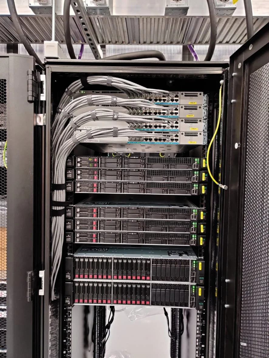 Fully configured data centre server rack with organised power distribution units and structured network cabling