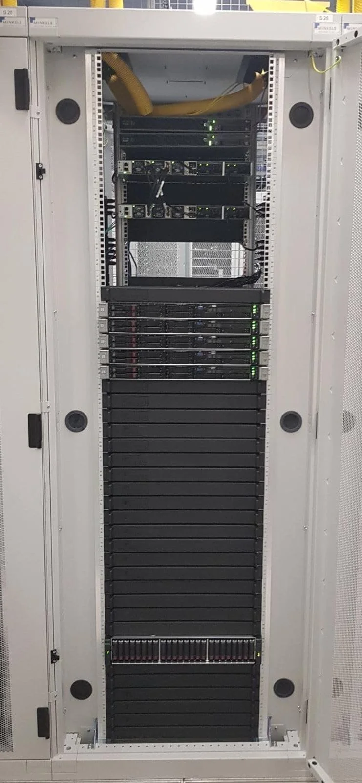 Fully populated data centre server rack with rack-mounted servers, networking equipment, and structured cabling