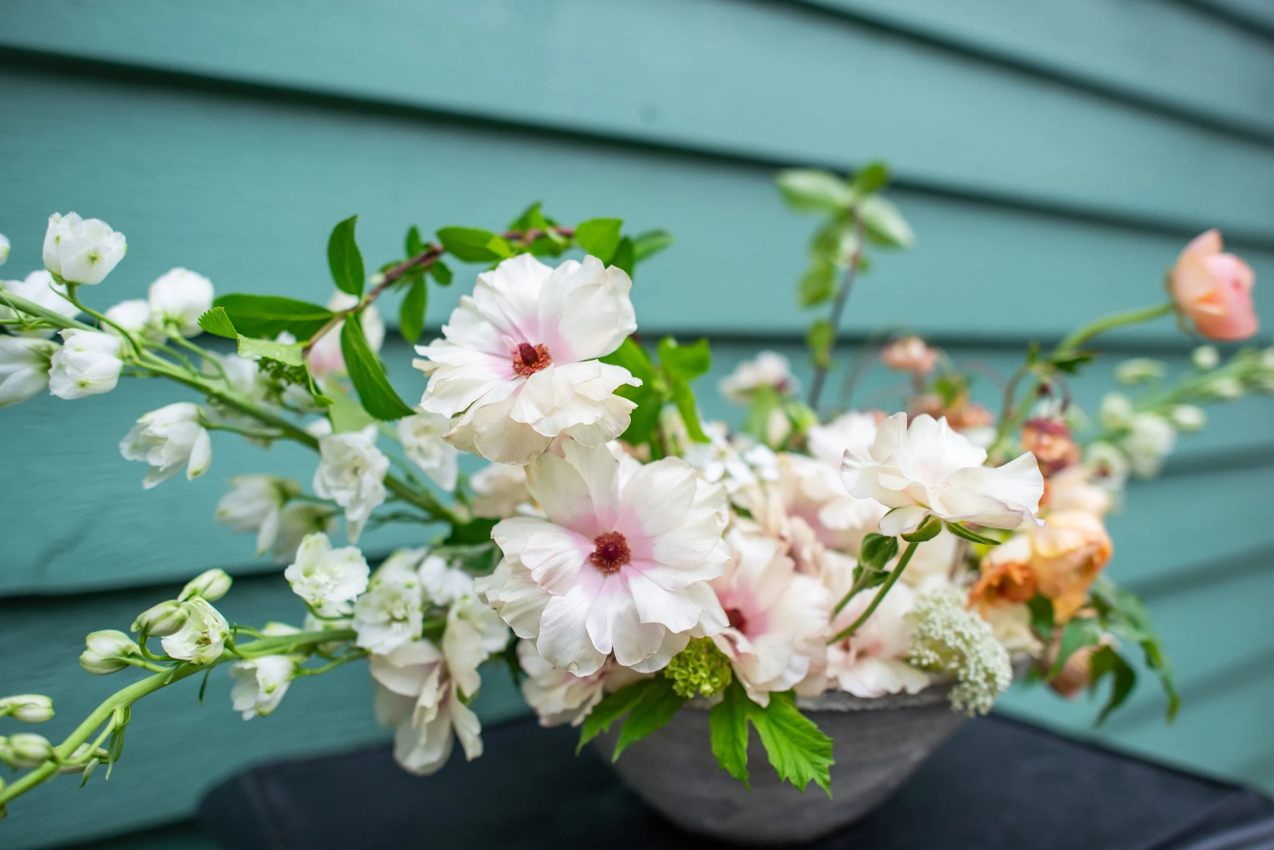floral arrangement with cream and peach flowers in a rustic vintage clay bowl