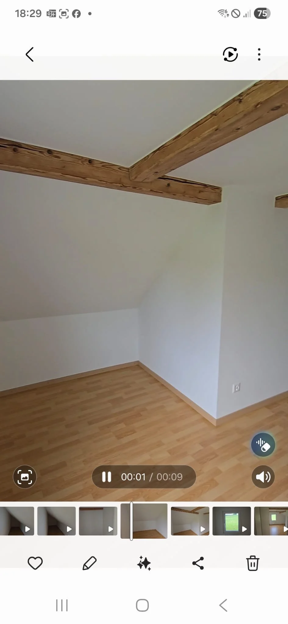 Empty room with wooden beams on the ceiling, white walls, and wooden flooring.