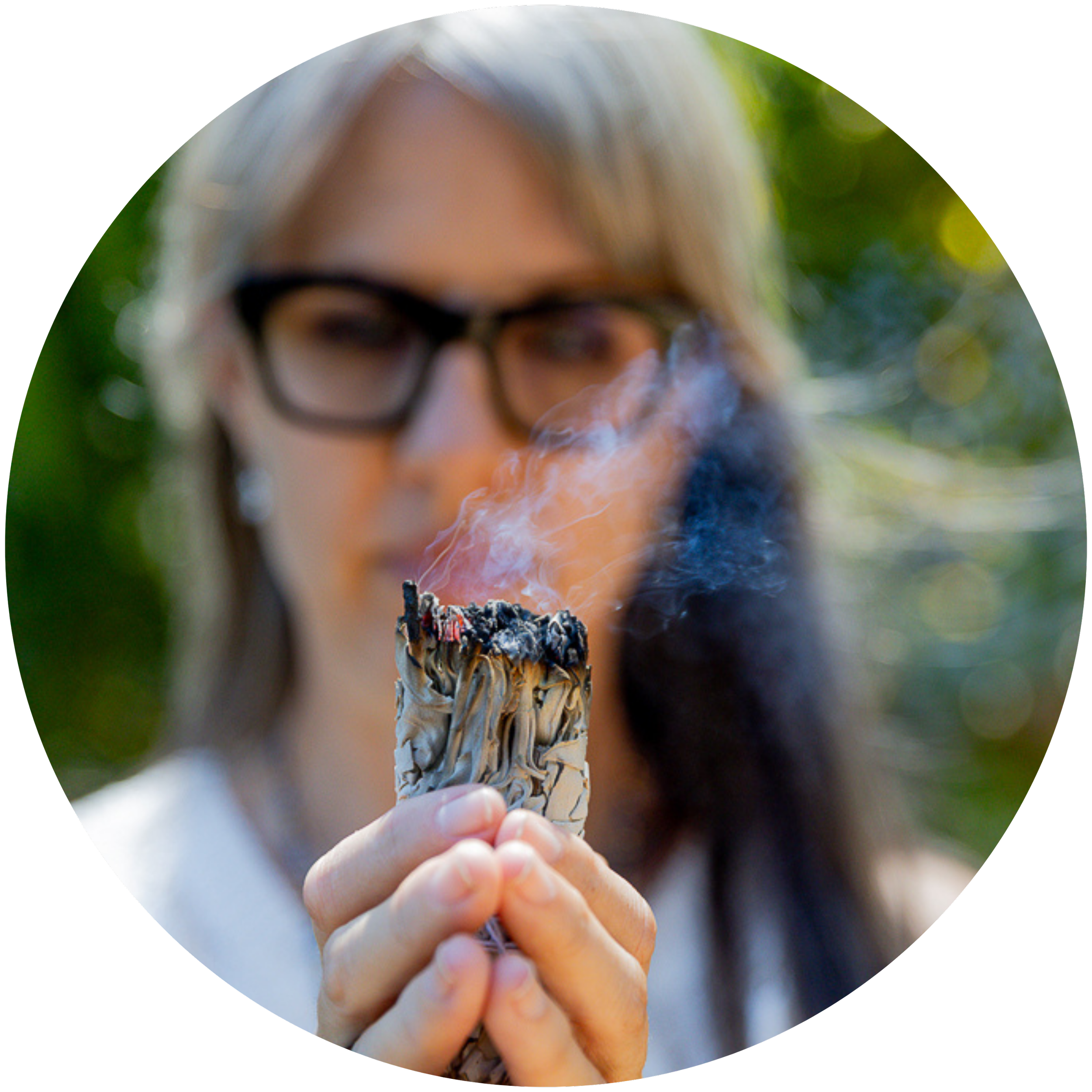 Alrina Laker using sacred smoke from a sage bundle during a shamanic energy medicine session