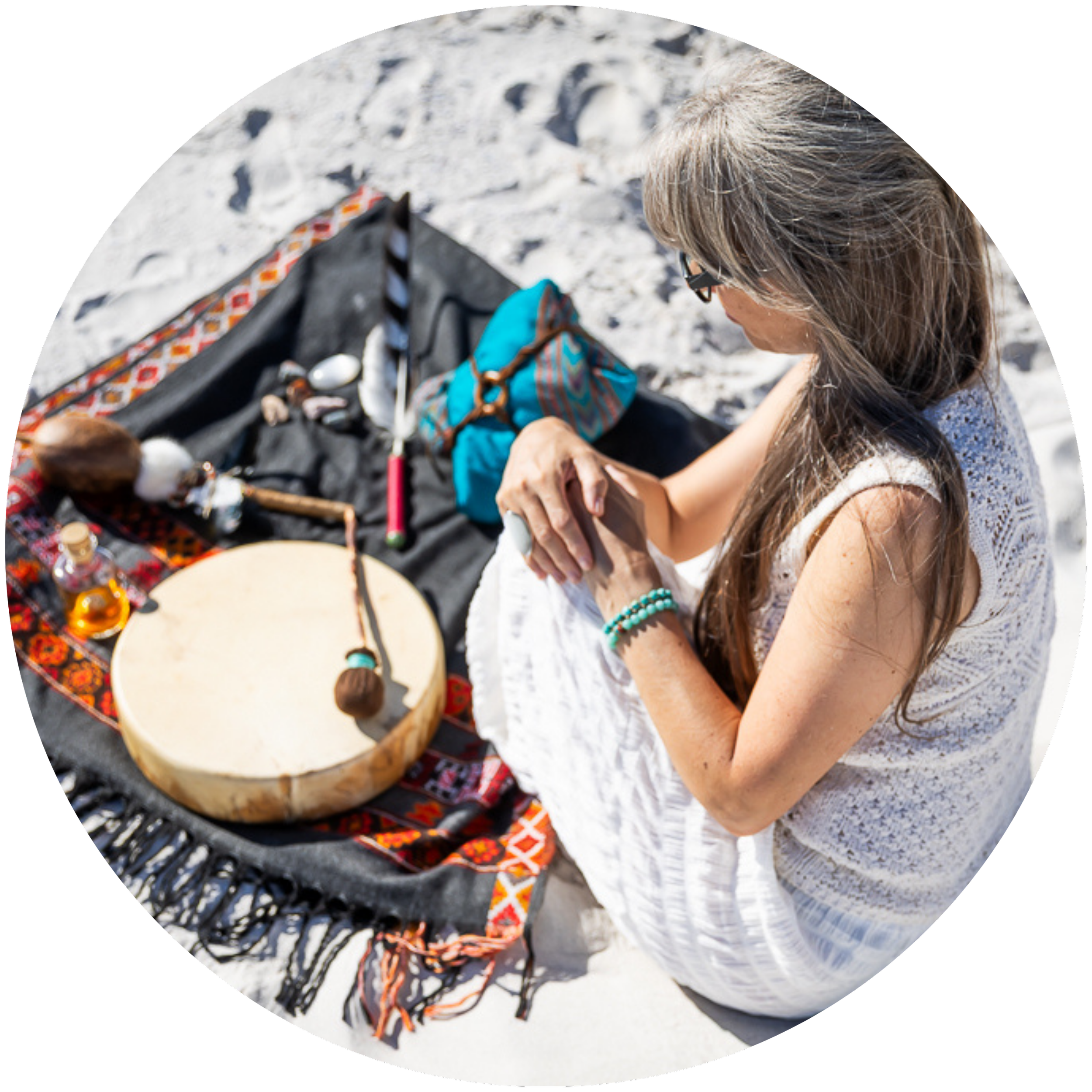 Alrina Laker seated outdoors with her shamanic drum and sacred ceremonial items representing the four-session Healing Path offering