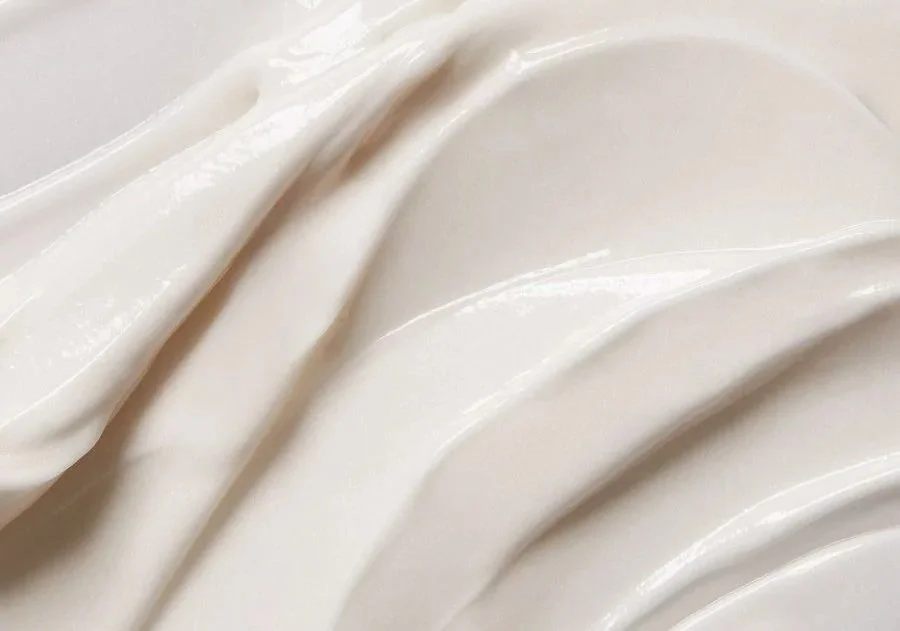 Close-up of a smooth, white, glazed ceramic surface with curved lines.