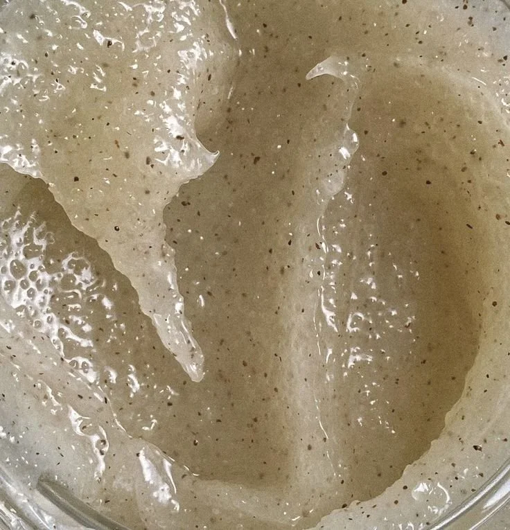 Close-up of a creamy, speckled beige substance, likely a batter or frosting in a jar.