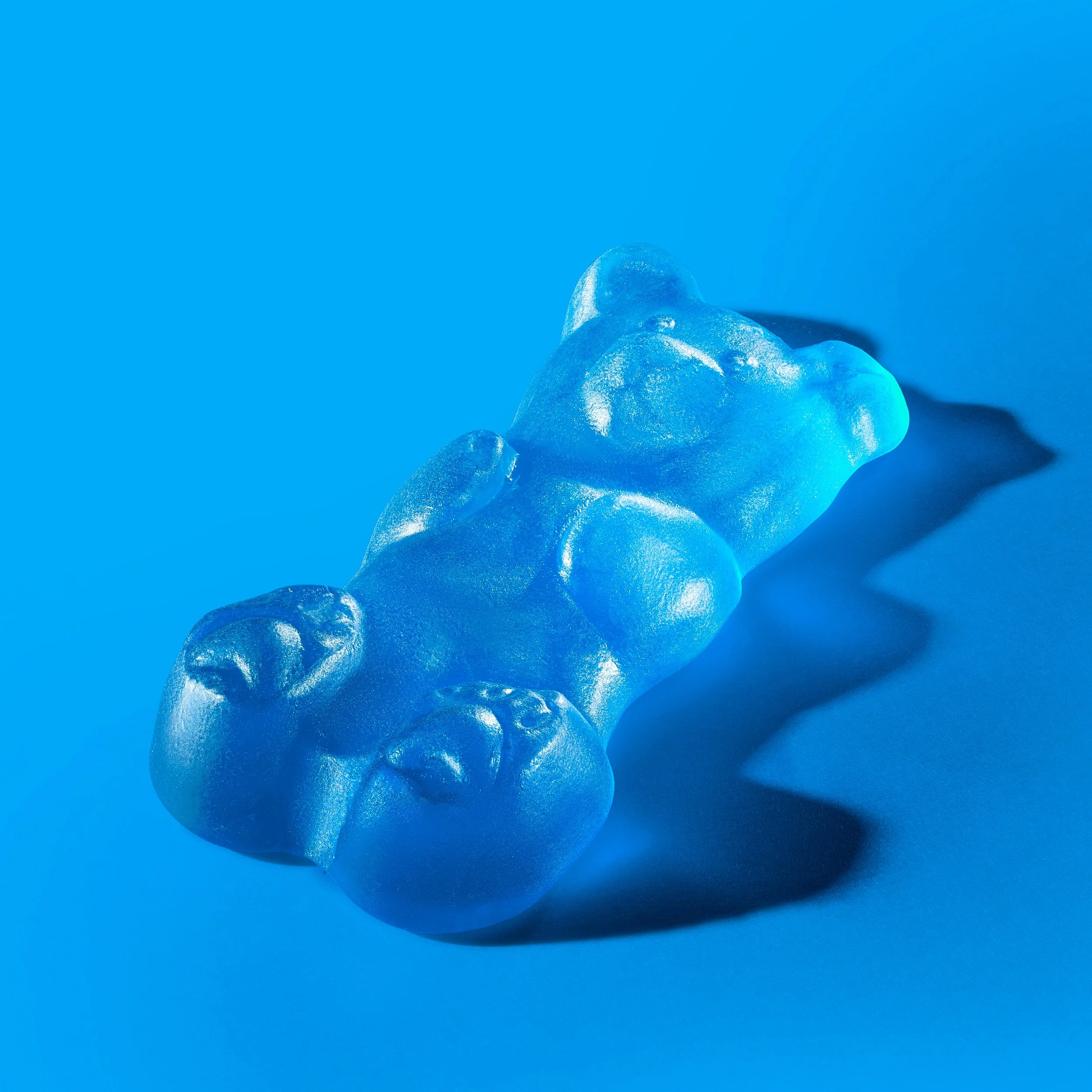 Blue gummy bear candy on a blue surface with shadow. Chicago Milwaukee Midwest Illinois Food Food beverage Food Drink Savory Photographers photographer photography videography videographer CPG Bennett Fuhrman Ben Tiny Scheme