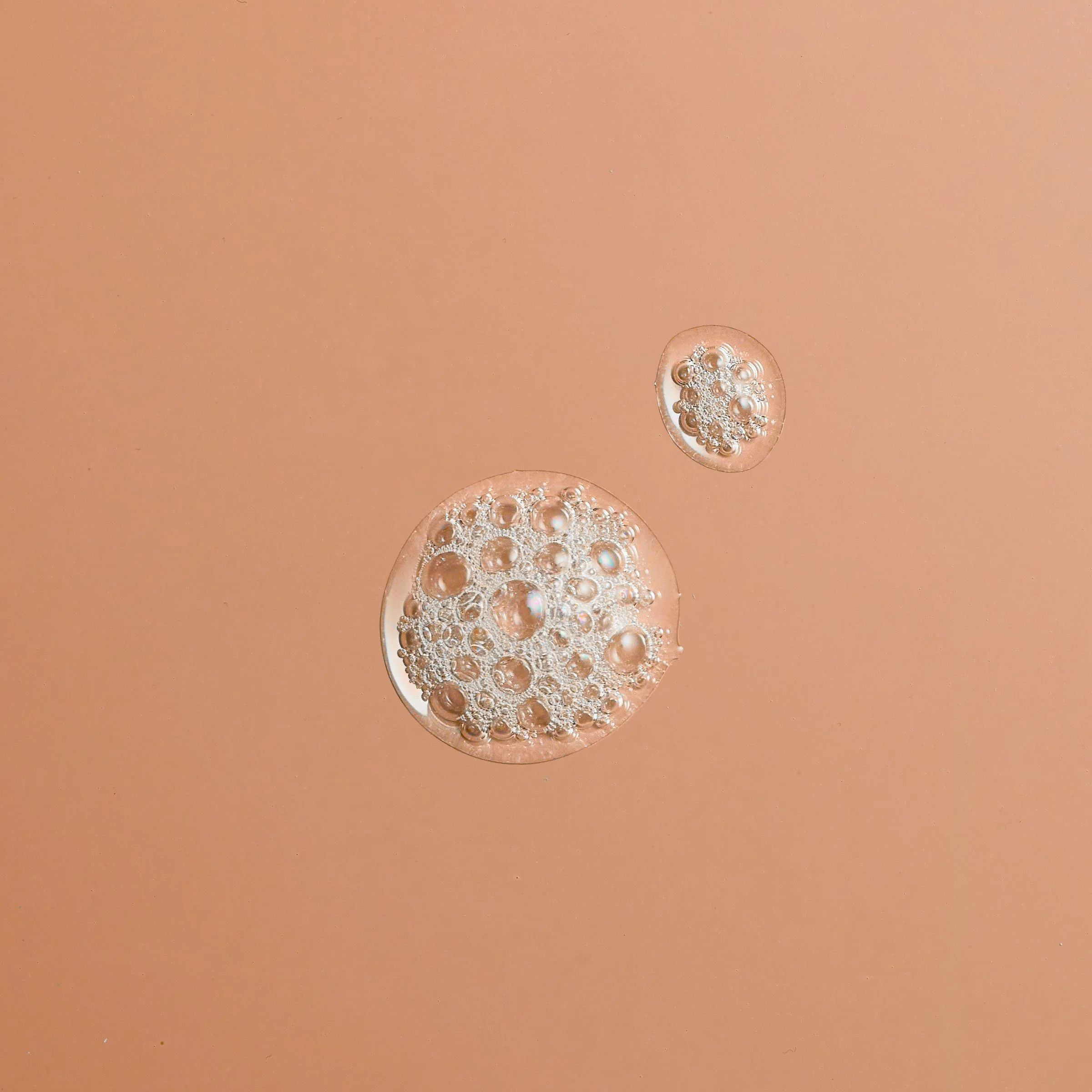 Close-up of two bubbles with smaller bubbles inside, on a peach-colored background. Chicago Milwaukee Midwest Illinois Food Food beverage Food Drink Savory Photographers photographer photography videography videographer CPG Bennett Fuhrman Ben Tiny S