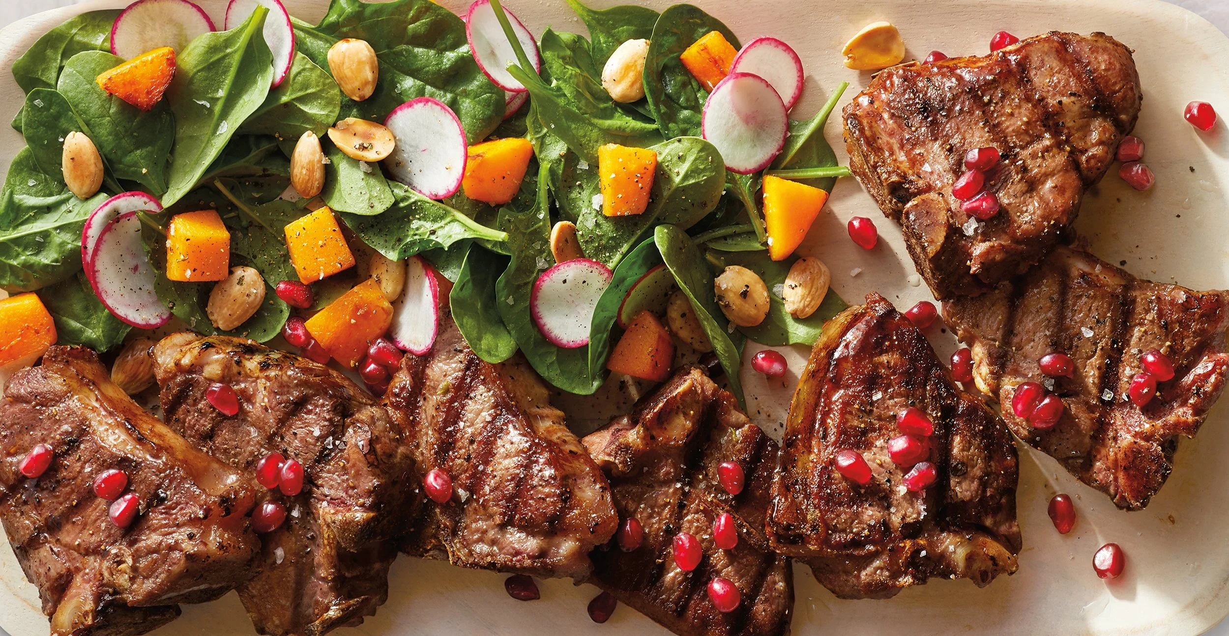 Grilled lamb chops with a side salad of spinach, radishes, orange chunks, pomegranate seeds, and almonds. Chicago Milwaukee Midwest Illinois Food Food beverage Food Drink Savory Photographers photographer photography videography videographer CPG Benn