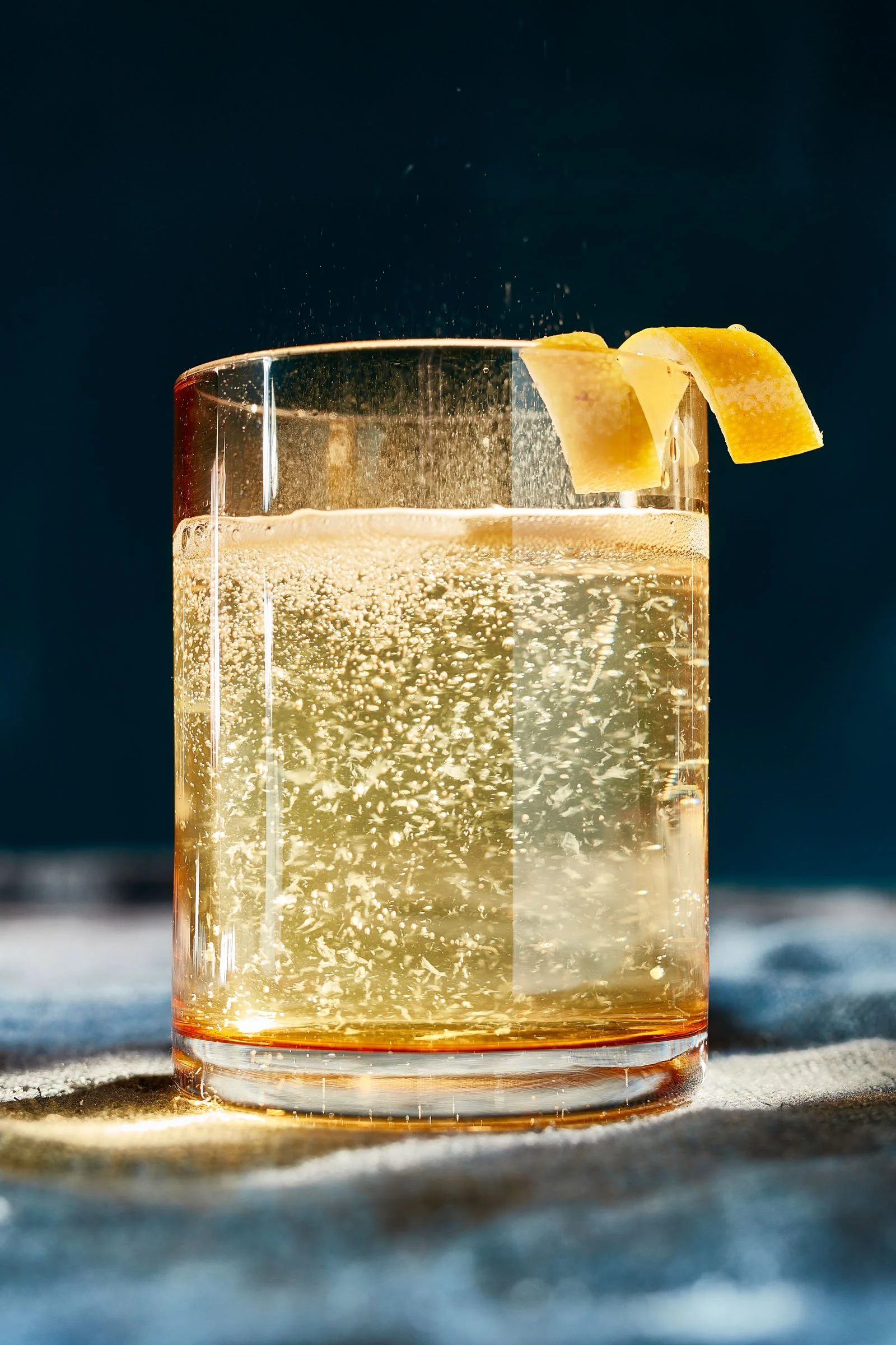 A clear glass of sparkling lemonade garnished with lemon wedges against a dark background. Chicago Milwaukee Midwest Illinois Food Food beverage Food Drink Savory Photographers photographer photography videography videographer CPG Bennett Fuhrman Ben