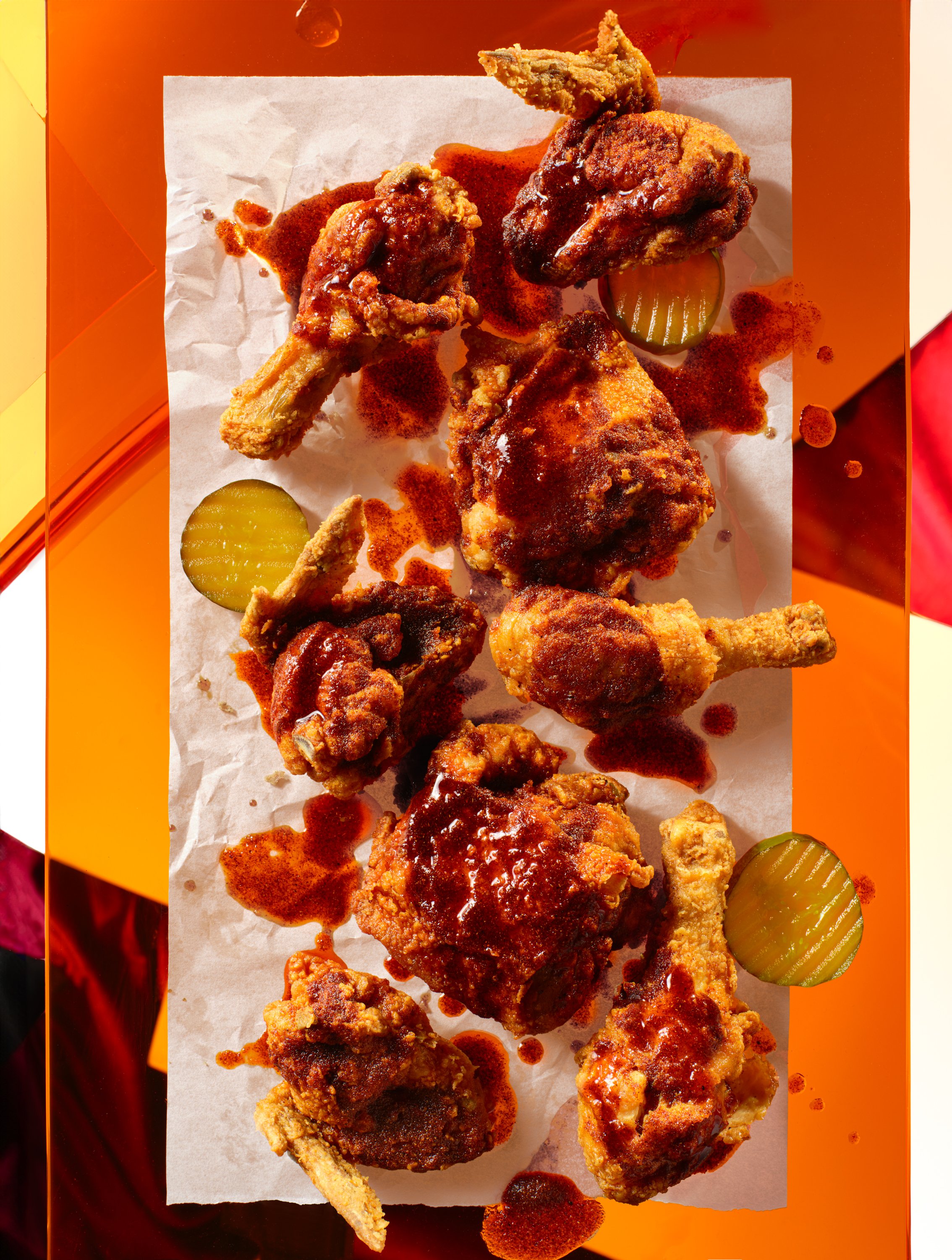 Fried chicken drumsticks and thighs with barbecue sauce, served with pickle slices on parchment paper. Chicago Milwaukee Midwest Illinois Food Food beverage Food Drink Savory Photographers photographer photography videography videographer CPG Bennett