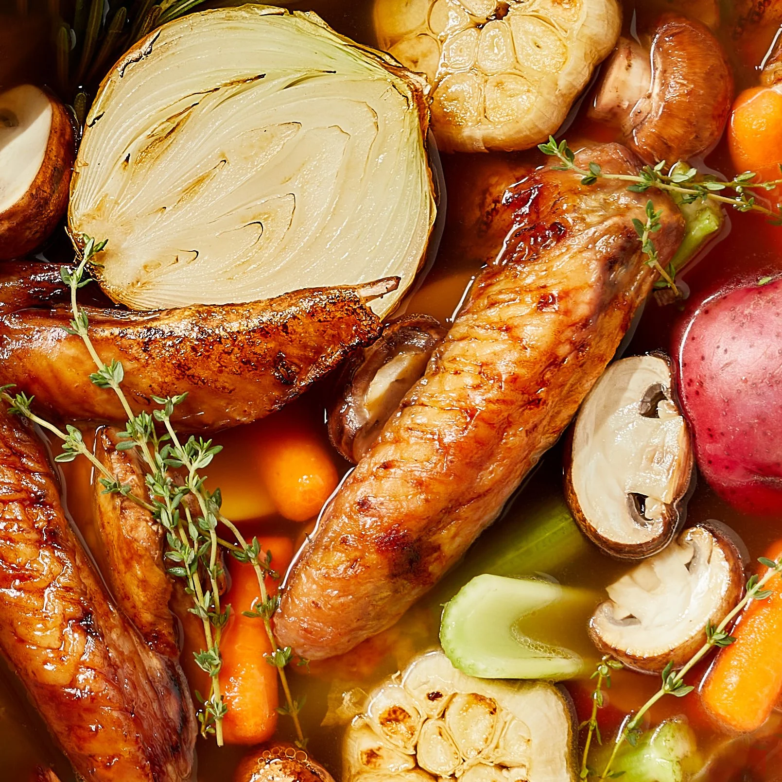 A roasted chicken leg, sliced garlic, carrots, mushrooms, a red onion, and fresh thyme herbs in broth. Chicago Milwaukee Midwest Illinois Food Food beverage Food Drink Savory Photographers photographer photography videography videographer CPG Bennett