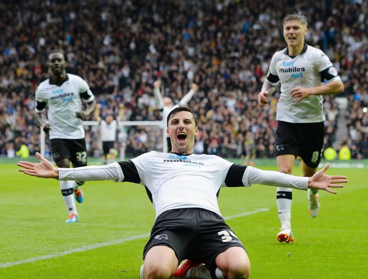 Footballer George Thorne does a knee slide to celebrate a goal with Derby County FC