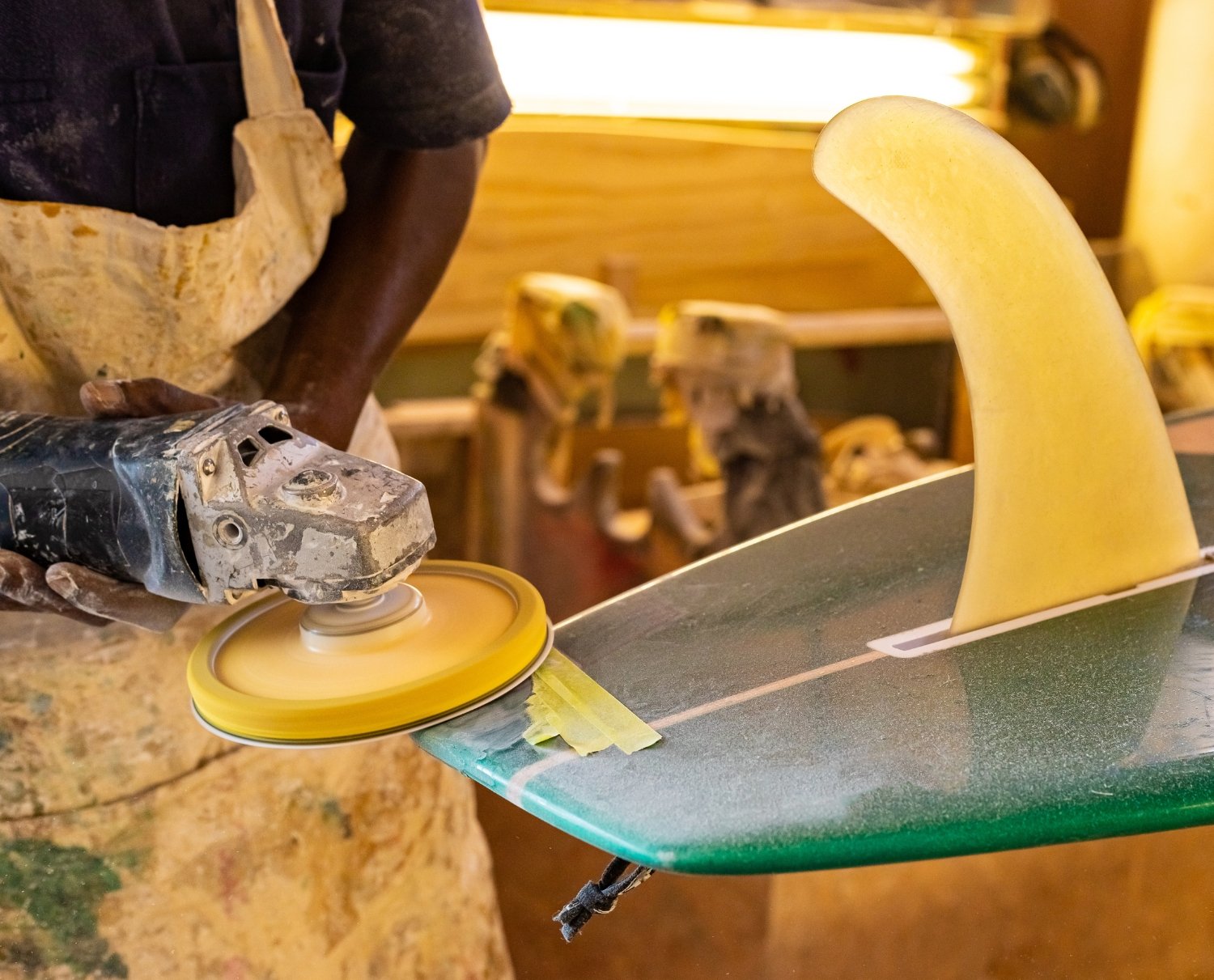 Surfboard shaper crafting a custom board. Bask Accounting provides expert bookkeeping, tax planning, and financial services for Hawaii's surf industry and small businesses.