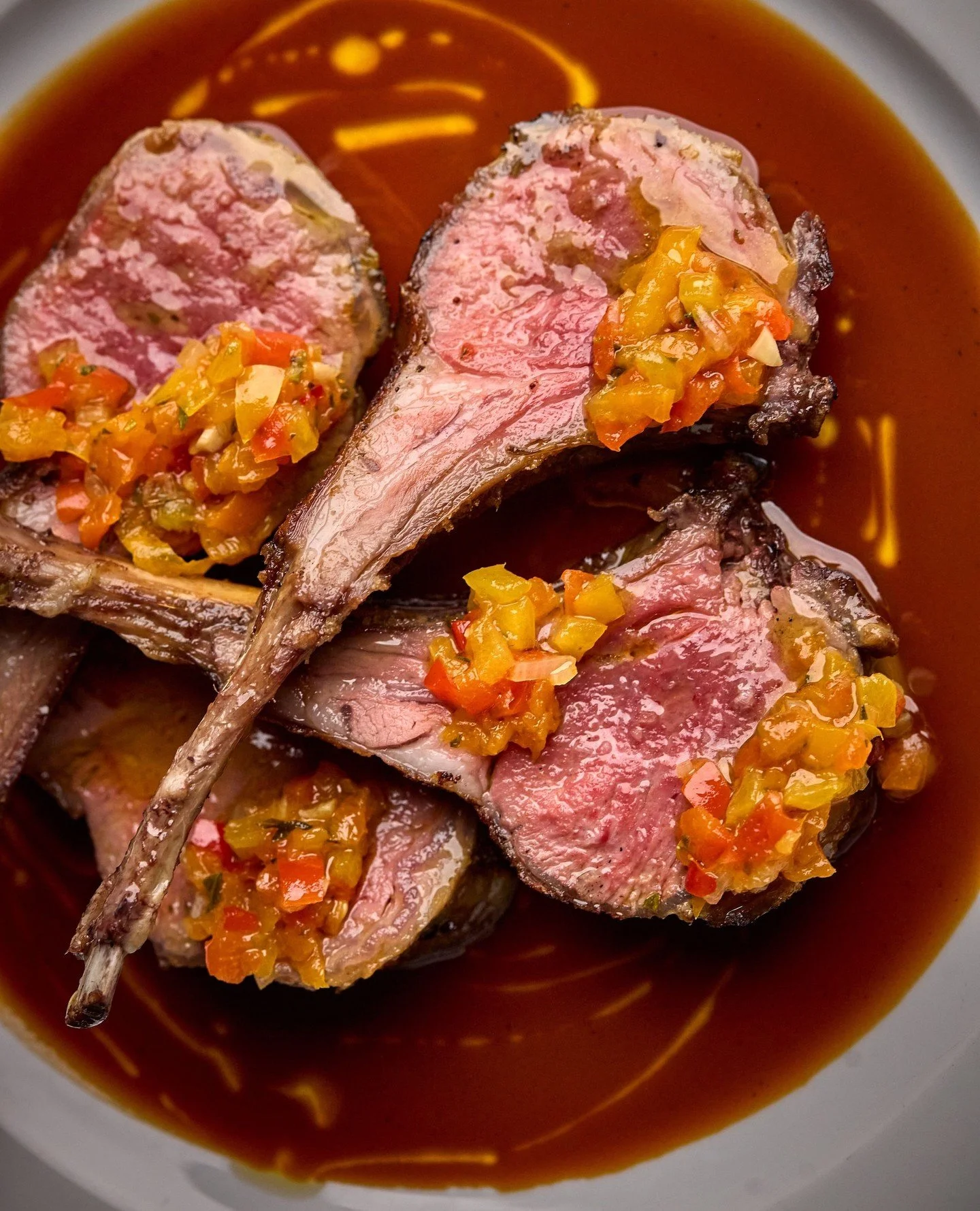 Every detail matters from grilling over kiln-dried oak to the final drizzle of Sicilian olive oil. Grilled Rack of Lamb with sweet pepper condiment and lamb jus.⁠