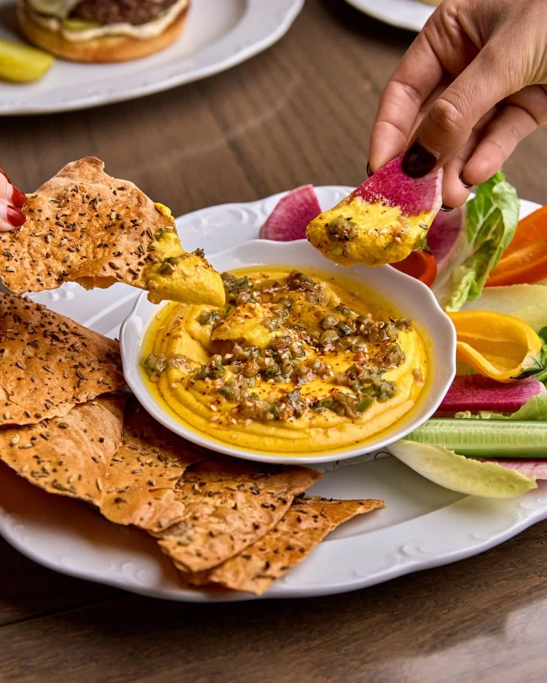 A few must-orders for your brunch table spread: Sesame Carrot Dip, Everything Focaccia &amp; Smoked Salmon, and Eggs In Purgatory.