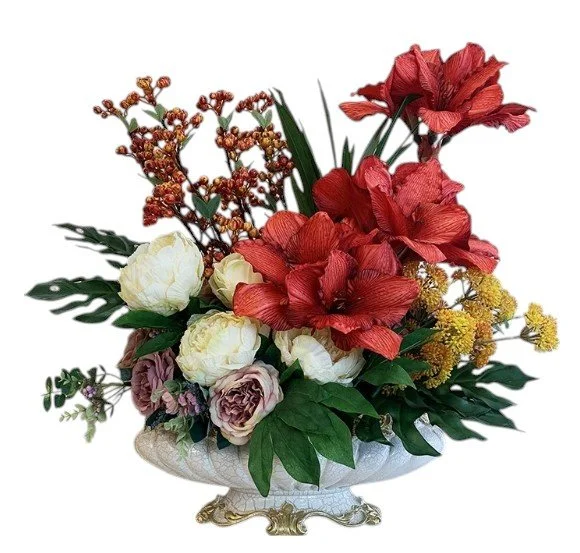 Elegant flower arrangement with red, white, and purple flowers in a decorative white ceramic vase.