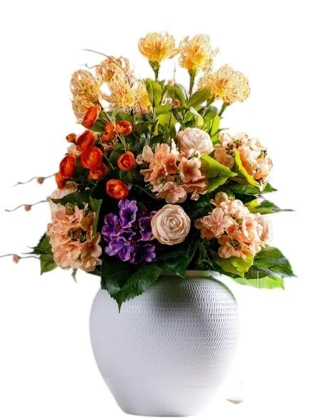 Arrangement of mixed flowers including roses, carnations, and other blooms in a white vase