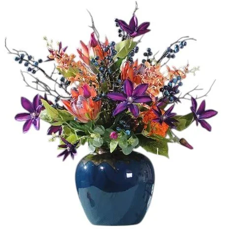 Colorful floral arrangement in a blue ceramic vase, featuring purple, orange, pink, and green flowers, with berries and branches.