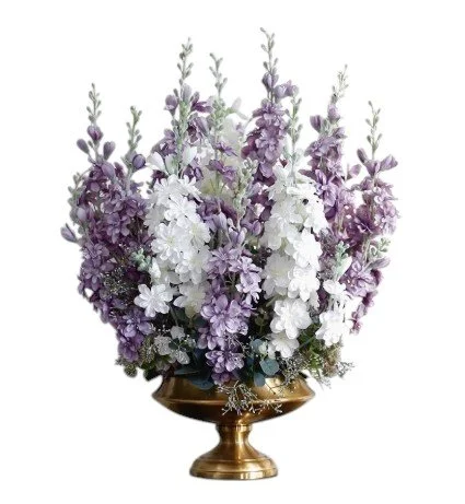 Arrangement of purple and white flowers in a gold vase