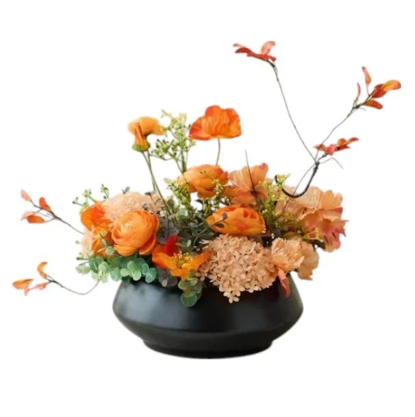 Arrangement of orange flowers and greenery in a black vase