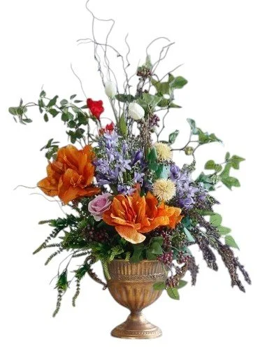 A floral arrangement featuring orange poppies, purple tulips, white chrysanthemums, and greenery in a gold vase.