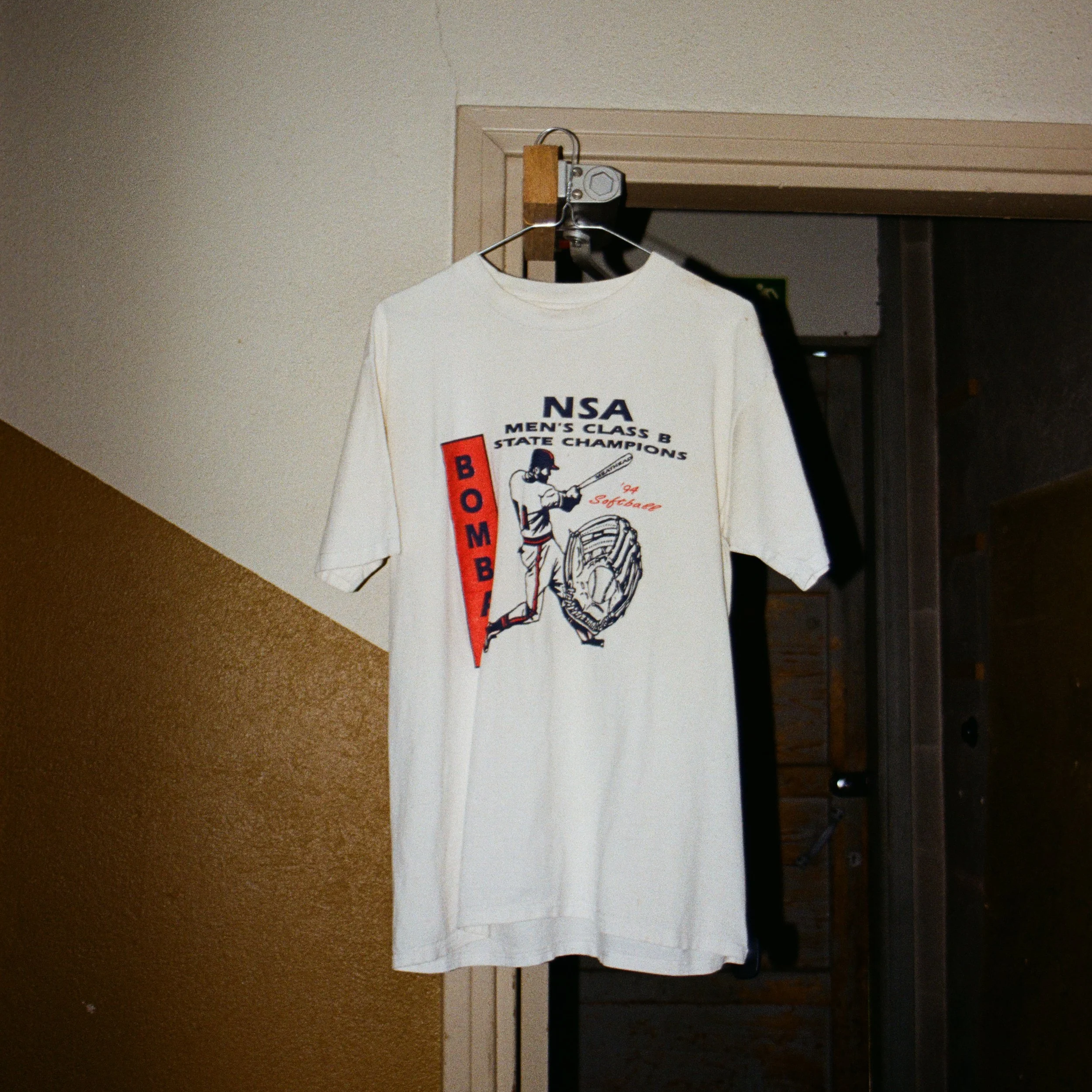Vintage T-paita, kuratoitu second hand -löytö Round2 Thriftshop and Coffee -kirpputorilta Jyväskylästä, roikkumassa oviaukossa