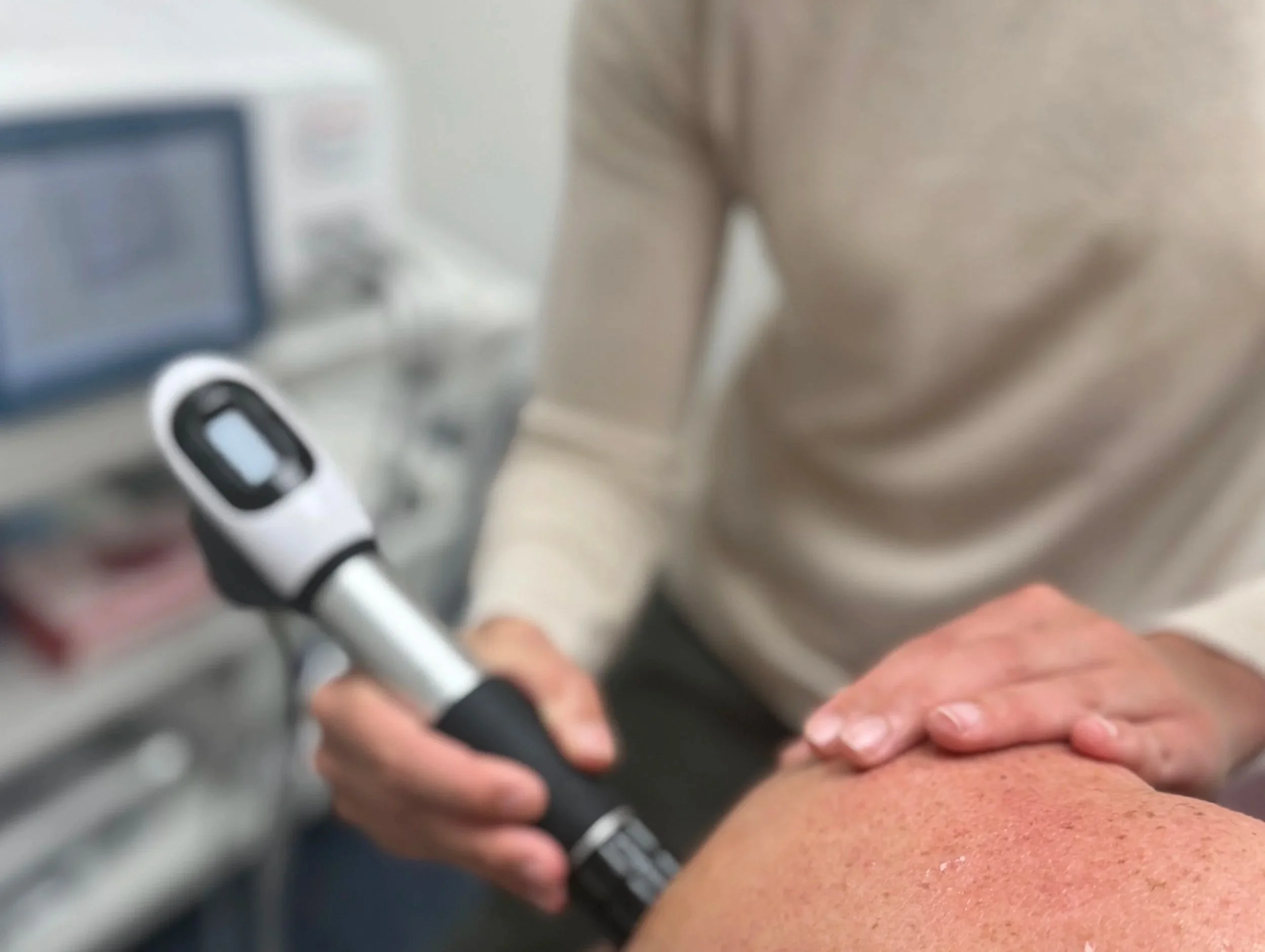 Dr. Leslie performing shockwave therapy on a patient’s shoulder at Destination Chiropractic in Boulder, Colorado