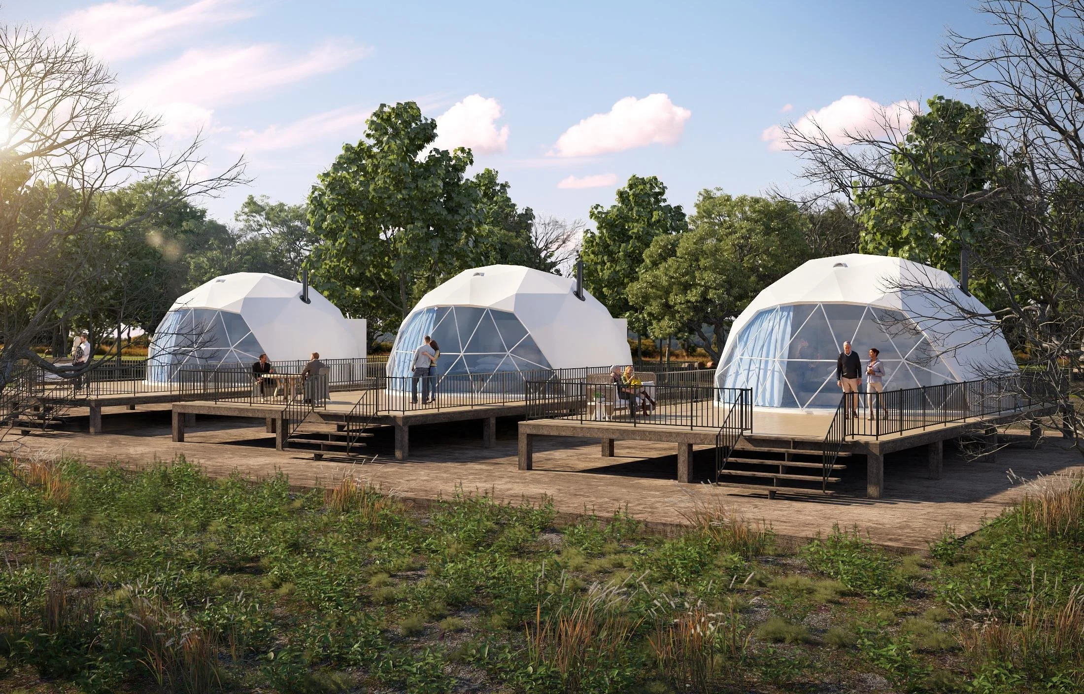 Three dome-shaped tents on elevated platforms with people enjoying the outdoor setting surrounded by trees and grass.