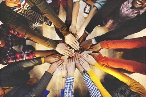 Diverse group of people with hands together in a circle
