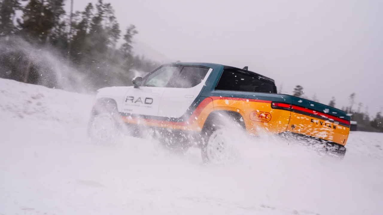 Camioneta eléctrica Rivian R1T con diseño RAD retro levantando nieve mientras derrapa en un campo invernal.
