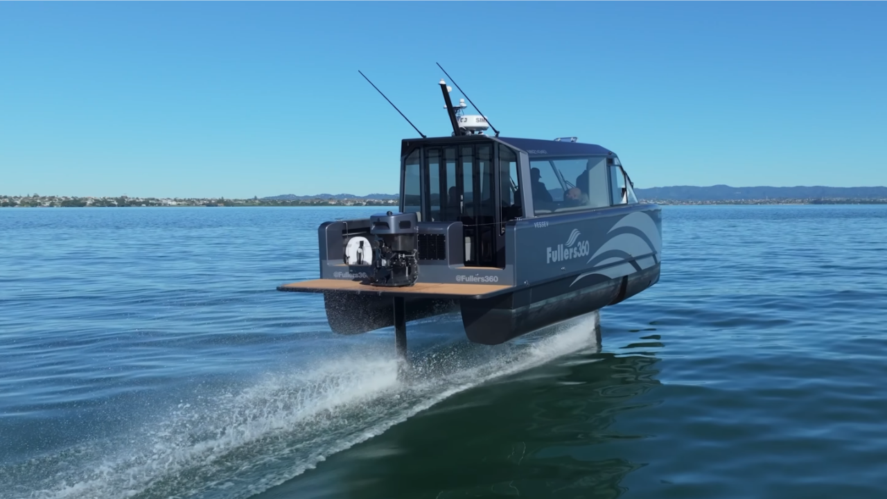 Barco hidroala eléctrico plateado Vessev VS-9 planea sobre agua azul durante pruebas de navegación sostenible.