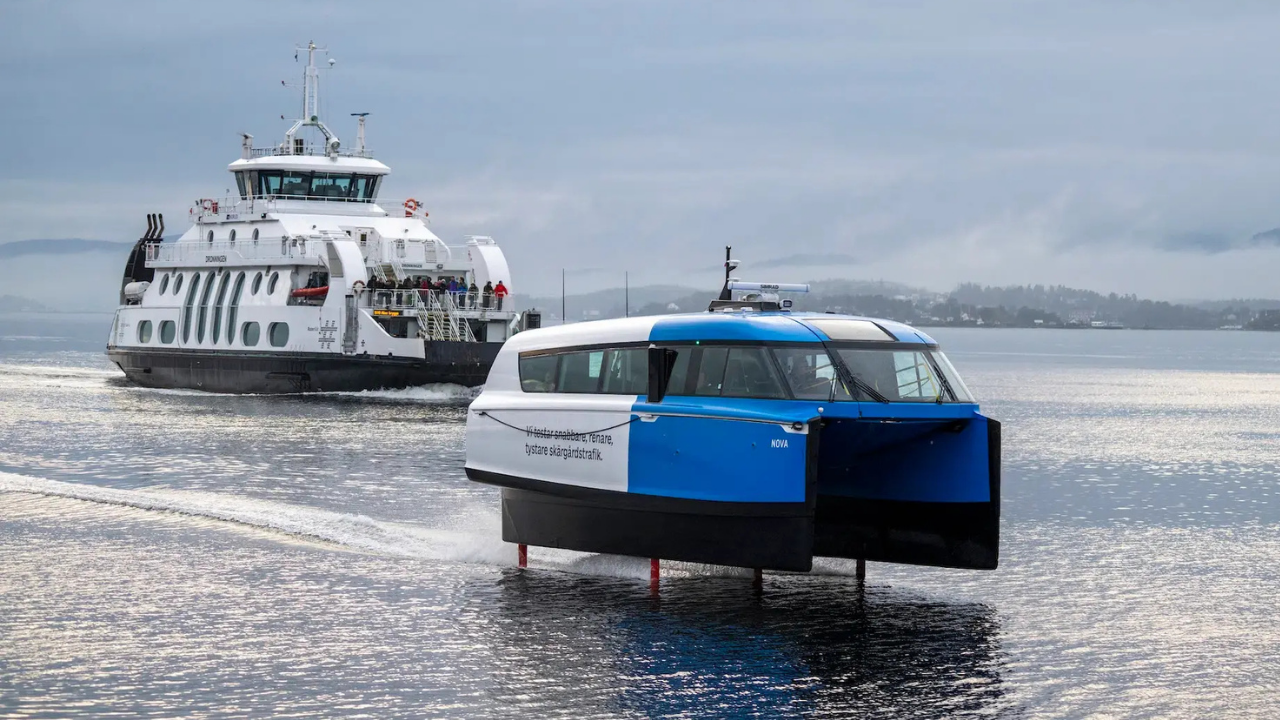 Candela P-12 azul y blanco volando sobre el agua tras un ferry grande. Innovación del Candela P-12 electric hydrofoil.