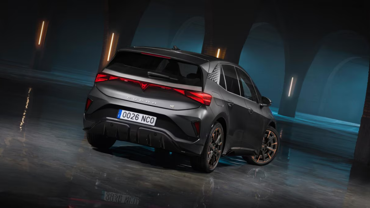 Vista trasera de un Cupra Born gris mate mostrando la barra de luces LED y llantas con detalles en cobre.