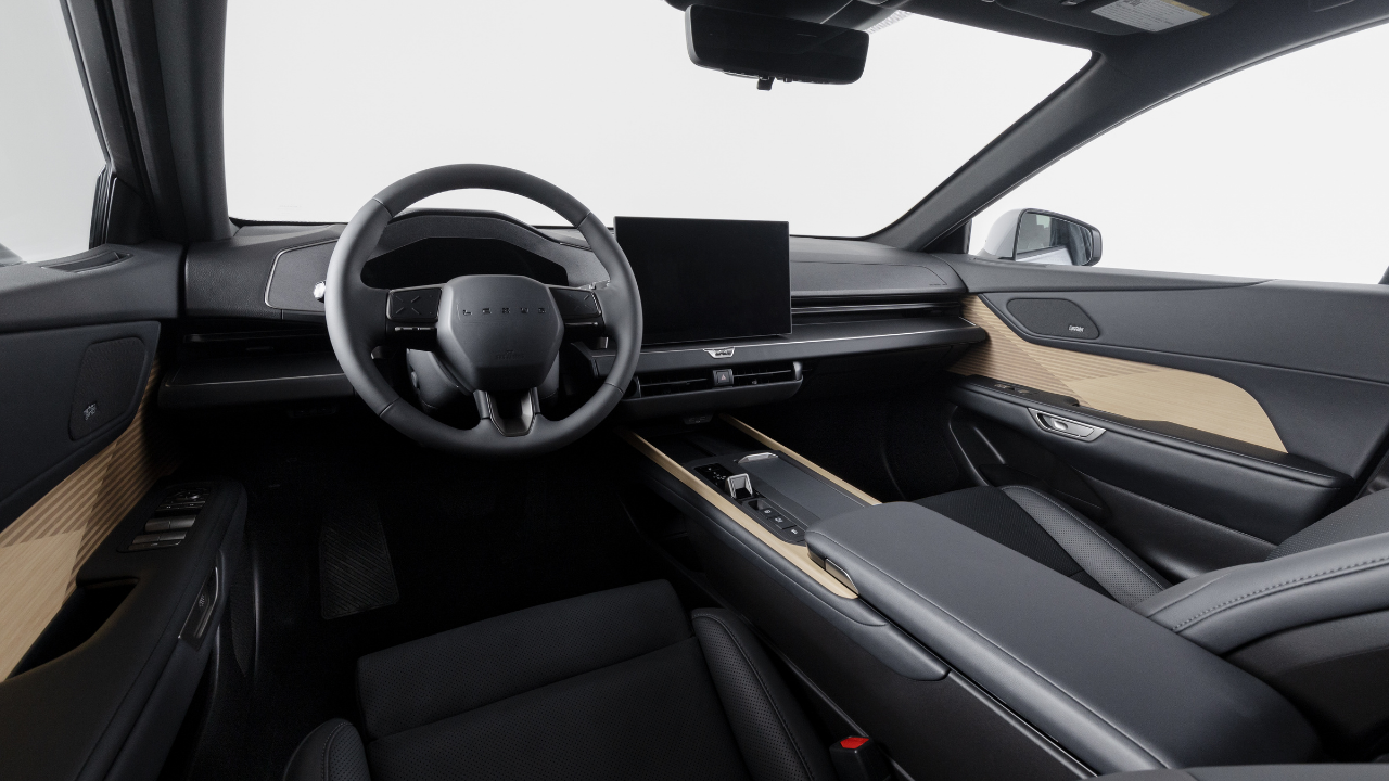 Interior minimalista de un Lexus ES 350e con una gran pantalla táctil, tapicería negra y detalles en madera clara.