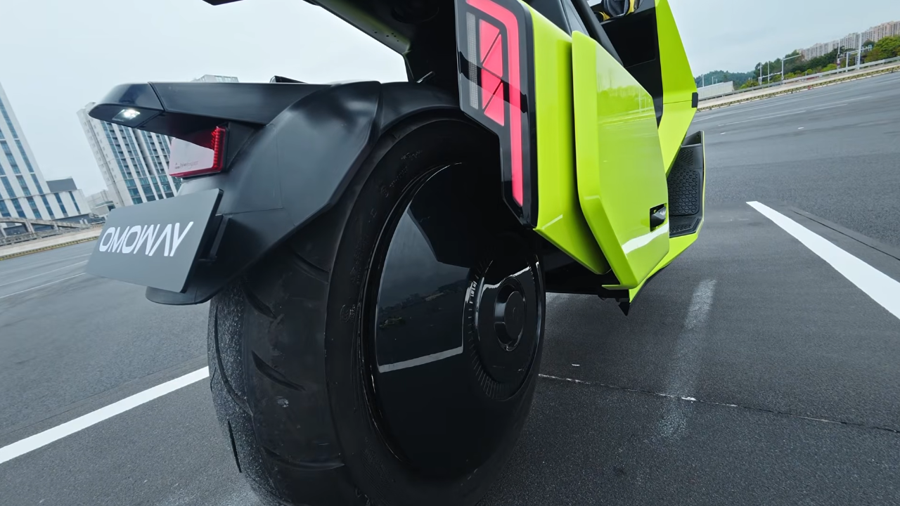 Vista trasera del scooter eléctrico Omoway verde neón con rueda negra sólida y luz LED roja. Diseño EV audaz.