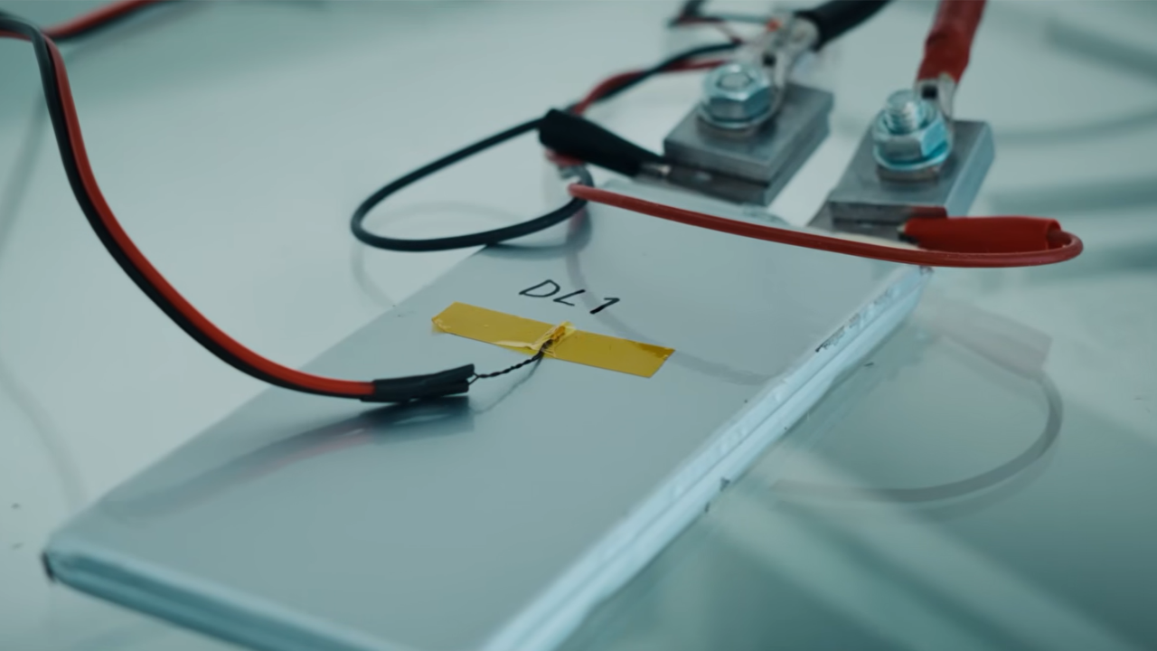 Celda de batería prototipo DL1 conectada a cables de prueba en laboratorio para desarrollo de baterías de VE.