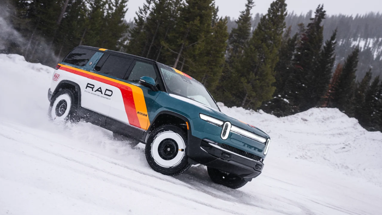 Rivian R1S con diseño RAD retro derrapando en nieve profunda entre pinos, demostrando potencia eléctrica invernal.