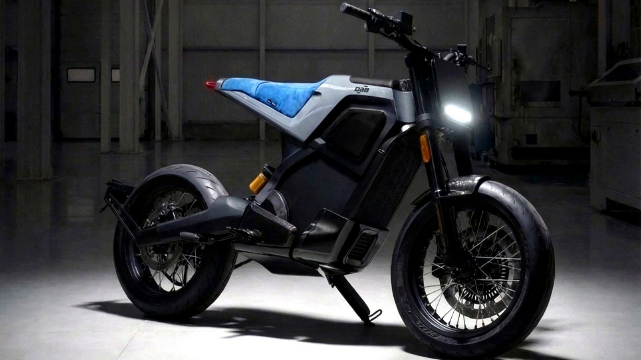 Moto eléctrica DAB 1alpha gris con asiento azul en un taller industrial oscuro. Movilidad urbana futurista.