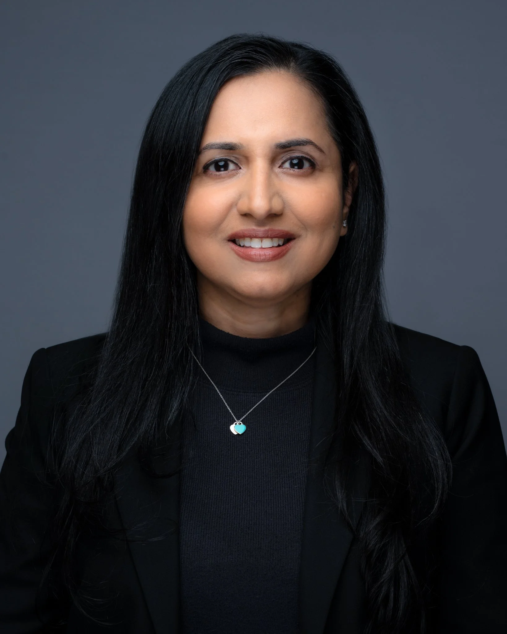 dark hair woman headshot wearing black outfit long hair