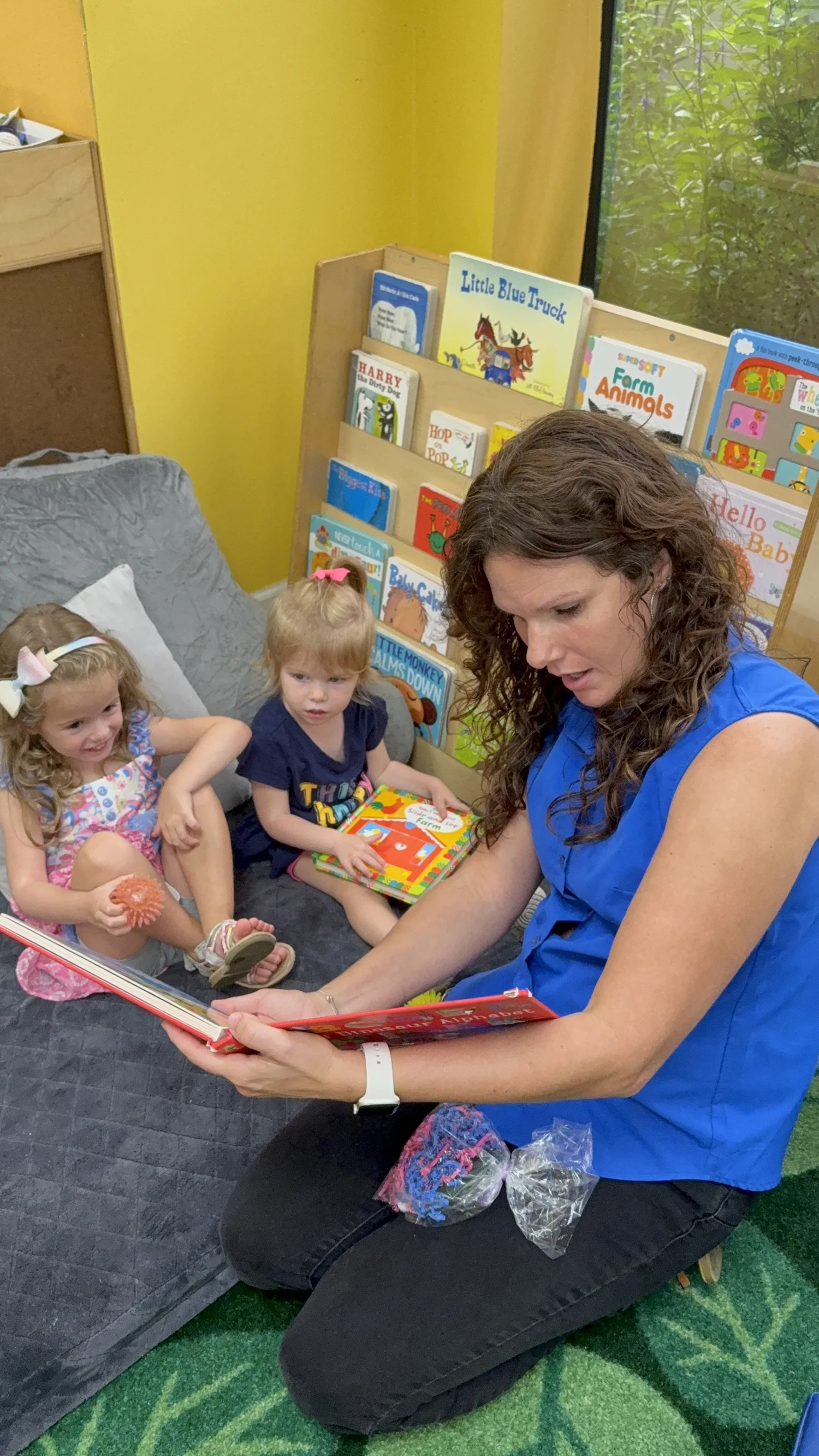 A teacher reading picture books with young children at Shalom Orlando
