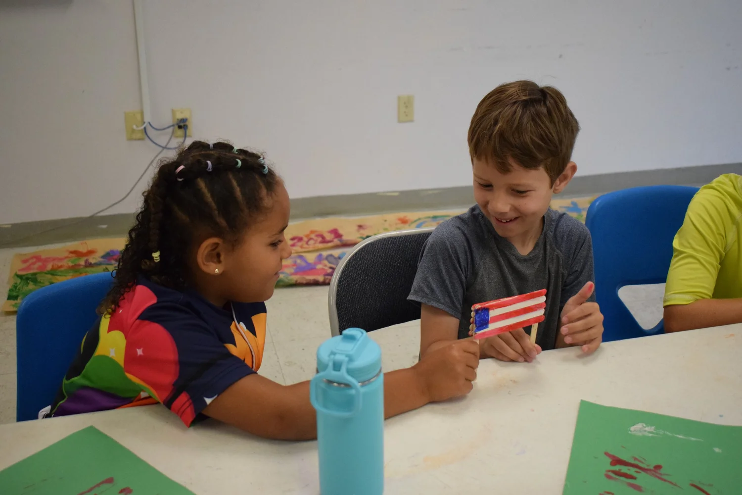 Children painting at a table in the Shalom Orlando craft class