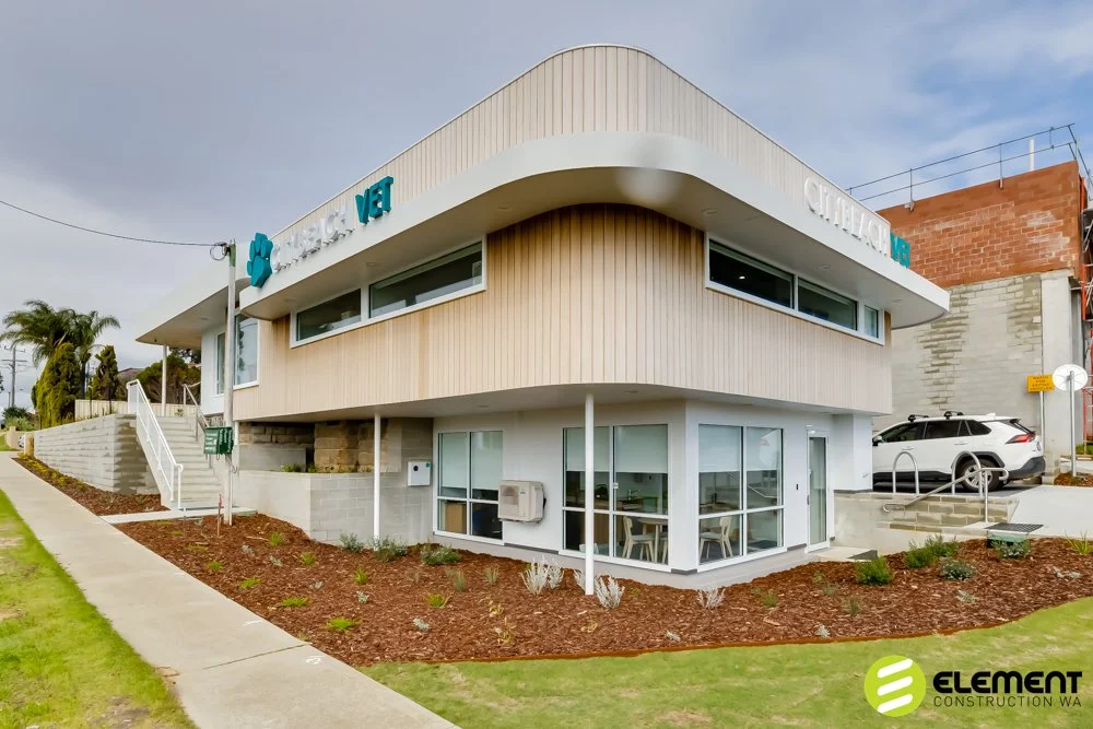 Modern two-story veterinary clinic with large windows, a white exterior, and signage for 'CHILLICO VET'.