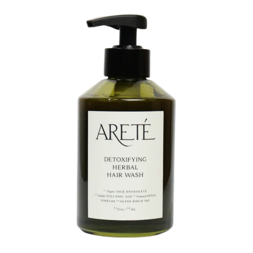 Bottle of Areté Detoxifying Herbal Hair Wash with black pump, dark green bottle, and white label.