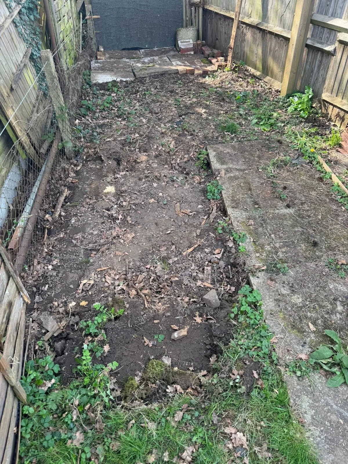 Original garden area before excavation, with uneven ground and poor surface conditions unsuitable for a concrete base.