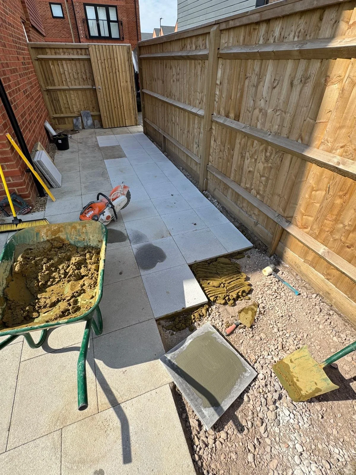 Progress view showing the new patio extension tying neatly into the existing paving.