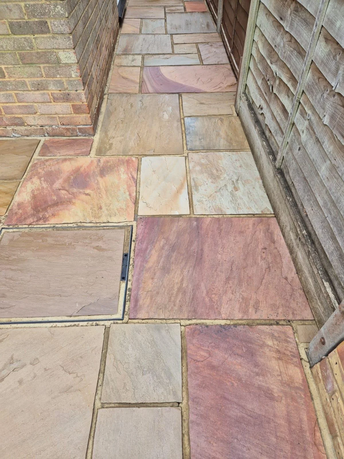 Freshly cleaned sandstone walkway with revived colour and crisp joint lines after sealing.