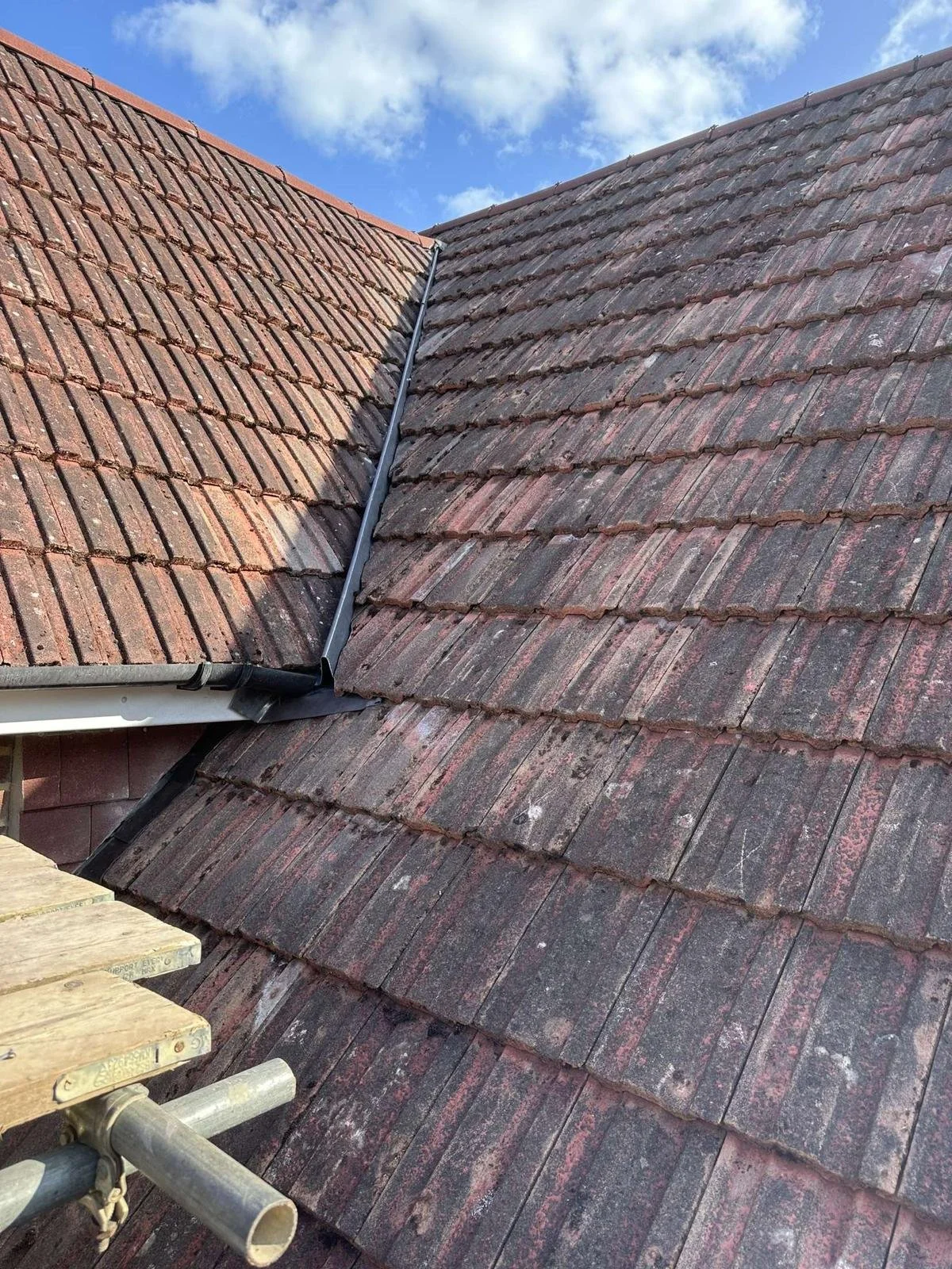 Cleaned tiles reinstated on the lower roof and fixed to new battens.