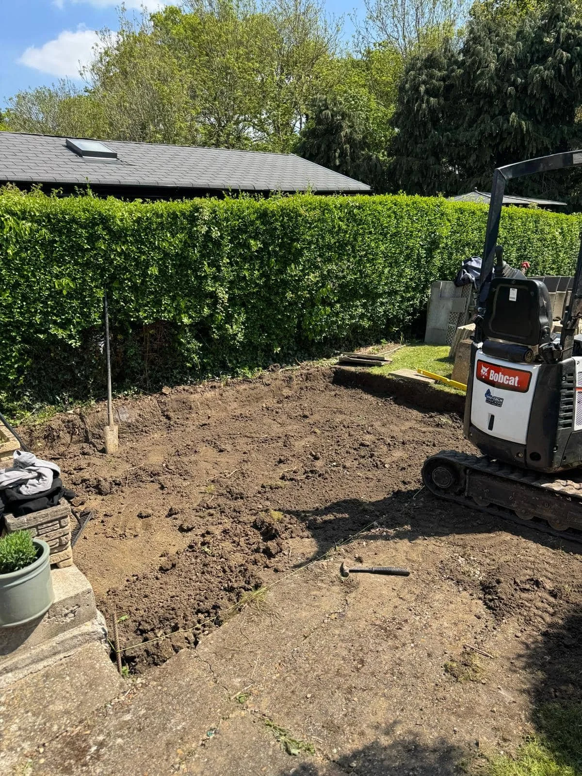 Ground excavation underway to create a solid, level base for the new patio installation.